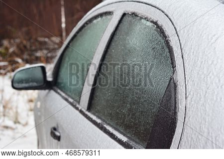 A Close-up Of A Car With Frozen Windows And Doors After Ice Storm In Winter. De-icing A Car Lock.