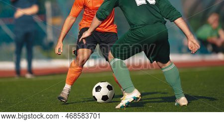 Two Adult Football Players Kicking Soccer Ball In A Duel. Soccer Competition Between Two Teams. Anon