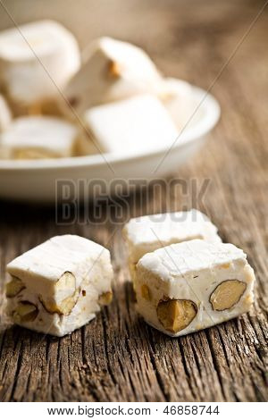  weißer Nougat mit Mandeln auf Holztisch