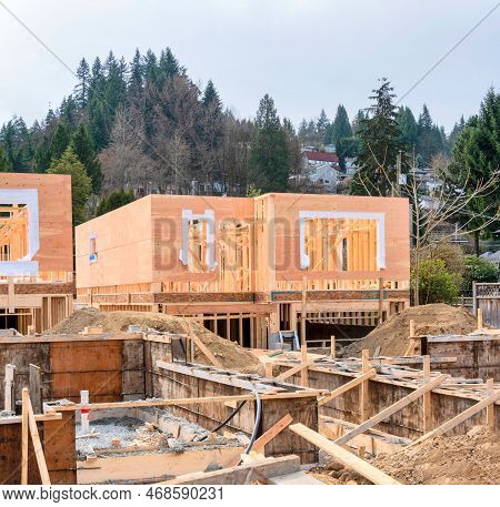 Wooden Frame Of New House With Concrete Filled Fundation In Front