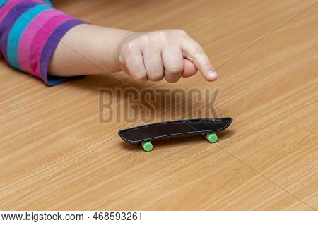 A Girl Rolls A Fingerboard On A Wooden Surface, Close-up, Finger Training