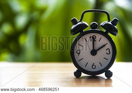 Alarm Clock Pointing At 2pm With Blurred Nature Background. With Customizable Space For Text. Copy S