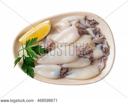 Raw Squid Fillet And Lemon On A Plate Cutout. Plate Of Small Calamary Tubes Isolated On A White Back