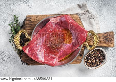 Flap Or Flank Steak, Raw Beef Meat In Skillet With Herbs And Olive Oil. White Background. Top View.