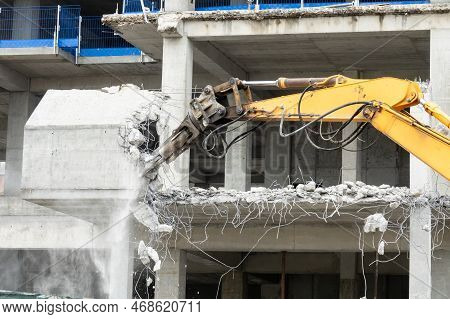 Excavator Machine With Hydraulic Crashers At Demolition Of The House. House Being Demolished By Spec