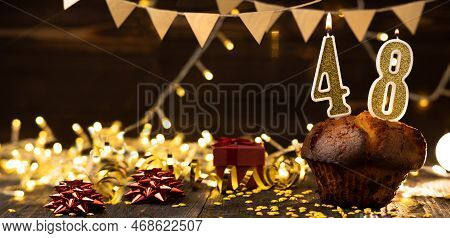 Number 48 Golden Festive Burning Candles In A Cake, Wooden Holiday Background. Forty Eight Years Fro