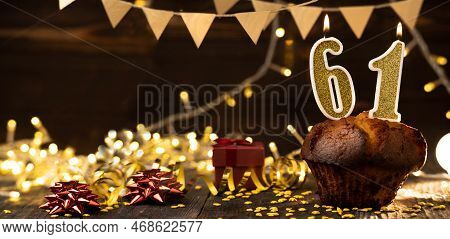 Number 61 Golden Festive Burning Candles In A Cake, Wooden Holiday Background. Sixty-one Years Since