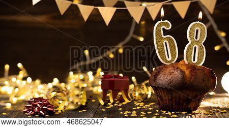 Number 68 Golden Festive Burning Candles In A Cake, Wooden Holiday Background. Sixty-eight Years Sin