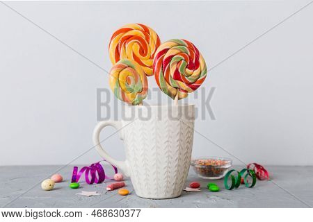 Colorful Candies In Cup On Table On Light Background Background. Large Swirled Lollipops. Creative C