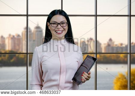 Portrait Of Lauging Business Woman With Tablet Pc. Checkered Windows With Cityscape On Background.