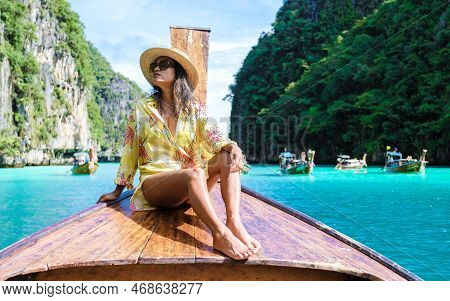 Asian Women In Front Of A Longtail Boat At Kho Phi Phi Thailand At Pileh Lagoon With Turqouse Water