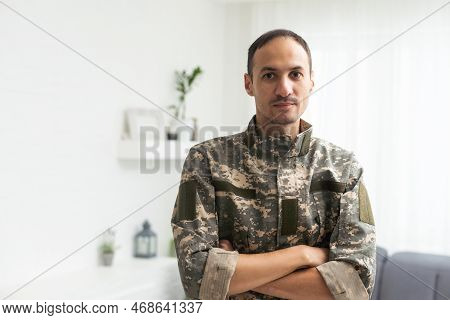 Thoughtful Military Man Staring Aside, Holding Palms By Mouth, Sitting On Couch At Home. Young Soldi
