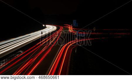 Long Exposure, White Front And Red Rear Lights As Car Light Strips At Night, German Text For Exit An