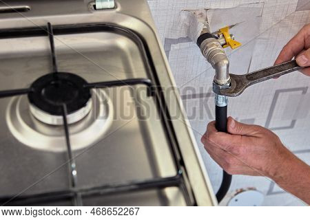 Gasman Disconnects Flexible Hose From Gas Stove.