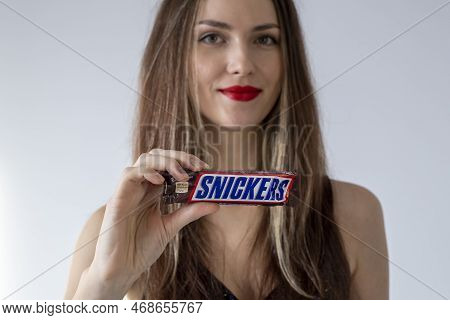 Irpen, Ukraine, December 2 20222, Girl Holding In Her Hand Snickers Candy Bar, Illustrative Editoria