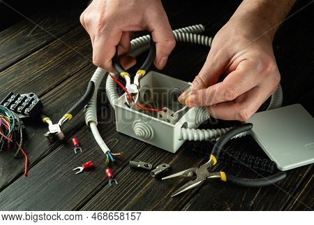 Professional Electrical Connection In The Workshop Of A Master Electrician. Close-up Of The Hands Of