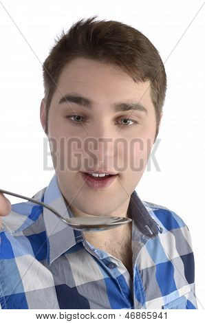 Young Man In Blue Shirt Is Smelling Spoon
