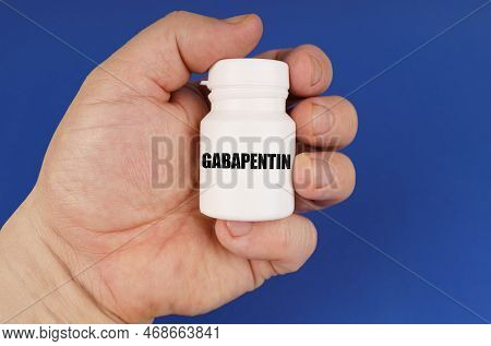 Pharmacology Concept. On A Blue Background In The Hands Of A Man Is A White Jar With The Inscription