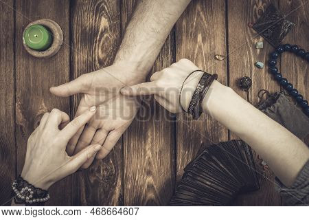 Fortune Teller Or Oracle In Search Of The Lines Of Fate In The Palm Of A Person. Divination By Hand,