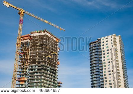 Building Site With Cranes New Development In The City. Concrete High Rise Residential Building Under