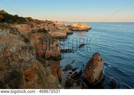 Stunning Sunset View Of The Secluded Beach And Colorful Cliffs From Praia Do Submarino In Algarve Re