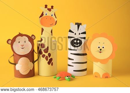 Toy Monkey, Giraffe, Lion And Zebra Made From Toilet Paper Hubs On Yellow Background. Children's Han