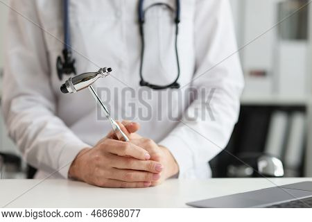 Doctor Neurologist With Hammer In Hands In Clinic. Neuropathologist Is Doctor Who Treats Diseases An
