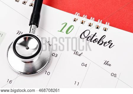 Stethoscope Medical And October 2023 Desk Calendar On The Red Background, Schedule To Check Up Healt