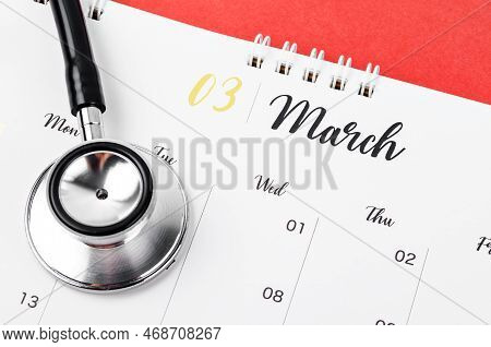 Stethoscope Medical And March 2023 Desk Calendar On The Red Background, Schedule To Check Up Healthy