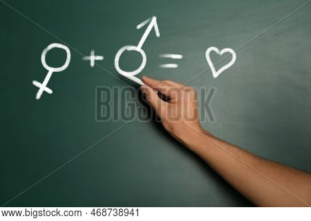Sex Education. Woman Drawing Male Gender Sign In Equation On Green Chalkboard, Closeup. Man Plus Wom