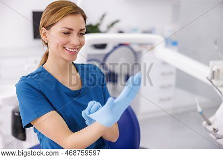 Female Doctor Putting On Protective Surgical Gloves While Working In Hospital