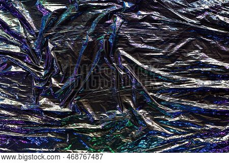 Black Color Plastic Wrap Background. Dark Crumpled Wrinkled Plastic Cellophane. Reflecting Colorful 
