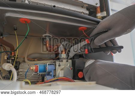 Man Repairing Gas Boiler With Waterpump Plier, Closeup