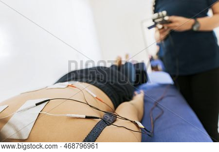 Electrode Treatment To Patient Lying Down, Professional Physiotherapist Electrostimulating A Lying P