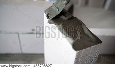 Applying Mortar When Laying A Wall Of Foam Blocks. A Bricklayer Makes A Concrete Wall From A Cement 
