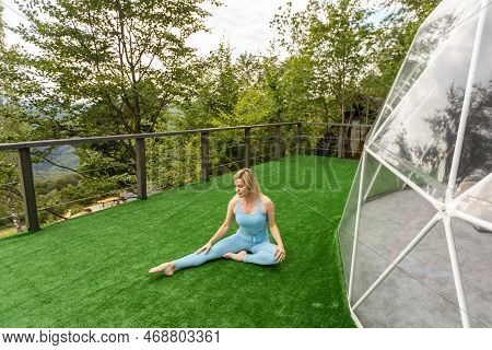 A Woman Is Doing Exercises On The Terrace Of A Transparent Bubble Dome