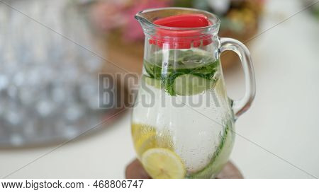 Drink With Lemon Slices And Cucumber In Jug On Table. Mint Summer Chilled Lemonade