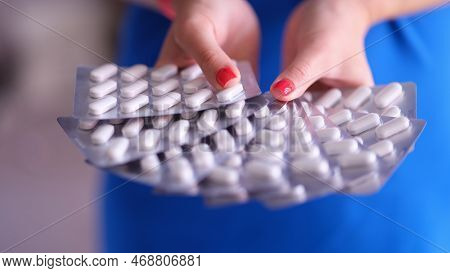 White Medical Round Pills In Metal Blister In Hand. Antiviral Immunomodulators Concept