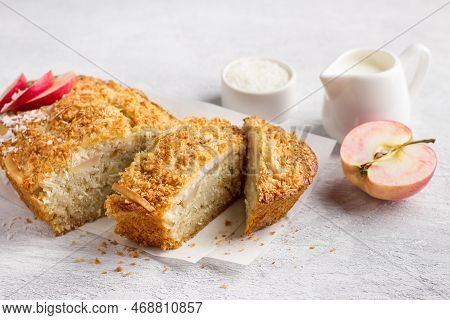 Coconut Cake, Mannik With Apples And Cream In A Ceramic Baking Dish On A Light Gray Textured Backgro