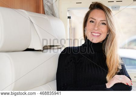 Young Blonde Cheerful Caucasian Woman Relaxing In Motor Campervan Home Vanlife