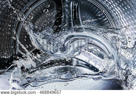 Washing Machine Drum With Clean Water Flow And Splashes. Laundry, Washing Powder Concept.