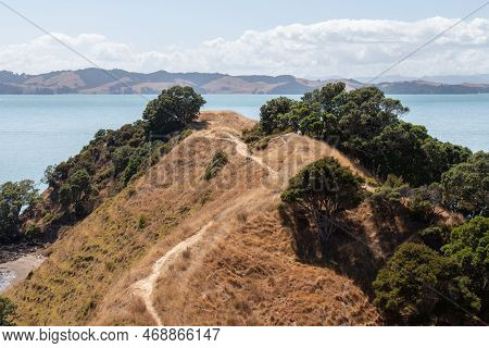 The View Of Picturesque Landscape With Hiking Trail, Dry Grass Slope And Blue Sea On Background In A