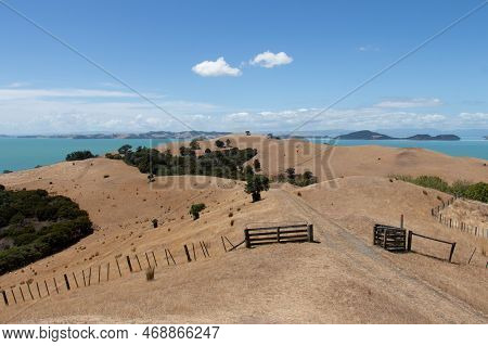 The View Of Picturesque Landscape With Field Of A Dry Grass, Blue Sea And Hills On Background In A S