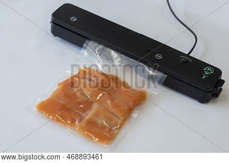 Vacuum Packaging Machine Packs Salmon Fillets In A Vacuum Bag For Pickling Or Sous-vide Cooking