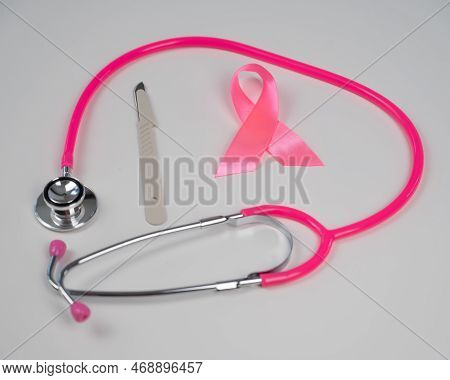 Pink Stethophonendoscope, Satin Ribbon And Scalpel On White Background.