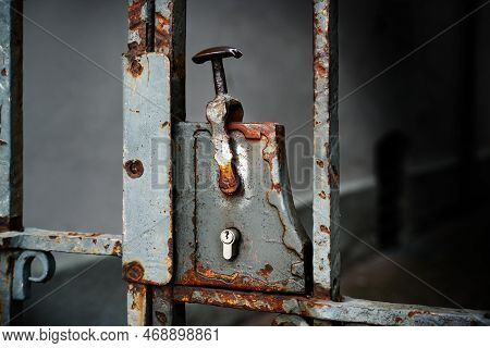 Nostalgic Rusty Door Lock With A Modern Lock Cylinder On A Metal Entrance Grille, Copy Space In The 