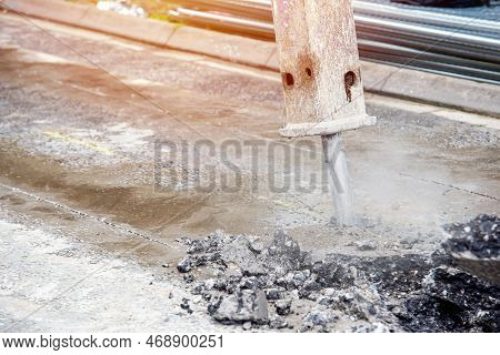 Excavator With Hydraulic Jack Hammer  Breaking Asphalt In Preparation For Drainage Works Close Up An