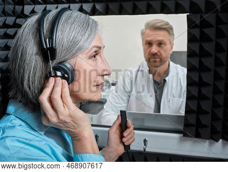 Hearing Testing. Female Patient Wearing Audiology Headphones Pressing Button Of Response While Audio