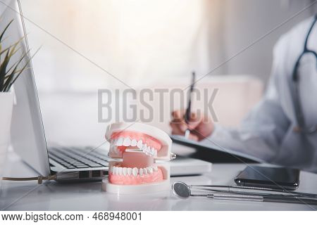 Oral Dental. Dentist Doctor In Uniform Writing Information Of Patient In Paperwork Checklist On Clip