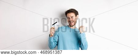 Happy Man Dancing With Plastic Credit Card, Smiling And Saying Yes, Celebrating On White Background